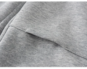 Macro detail of reinforced pocket stitching and heather grey knit texture on boys' joggers