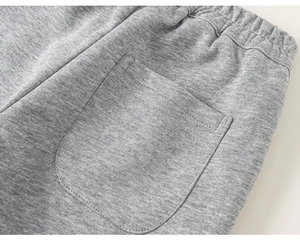 Detail of grey knit joggers featuring elastic waistband and reinforced back pocket stitching