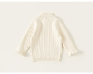 Detail of ribbed knit fabric on cream toddler sweater with fluffy ruffle cuffs