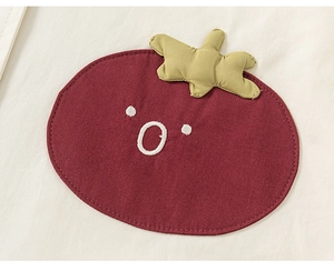 Gros plan sur la broderie de tomate mignonne sur le tissu en coton de la veste enfant