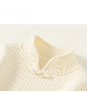 Detail of ribbed knit sweater featuring mandarin collar with pearl button accents