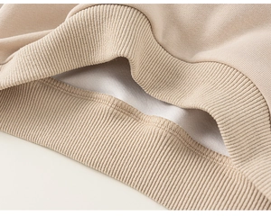 Détail macro des poignets élastiques en maille et de la doublure en polaire du sweat enfant