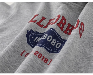 Close-up of gray knit fabric with vintage LLFORDS and BOBO seal screen printing