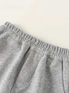 Close-up of boys gray jogger pants featuring elastic waistband and soft knit texture