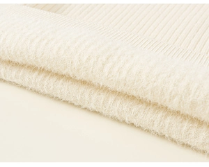 Close-up of off-white ribbed knit fabric with soft fluffy texture and high-quality yarn