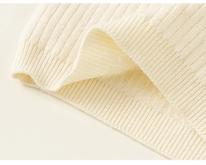 Macro detail of kids' cream knit sweater with warm plush lining and ribbed texture