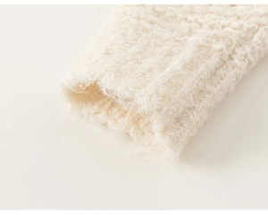 Detailed macro view of the fluffy ribbed cuff on this cream-white knit girls sweater