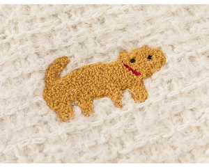Detailed view of soft beige knit fabric featuring a cute ginger puppy embroidery design