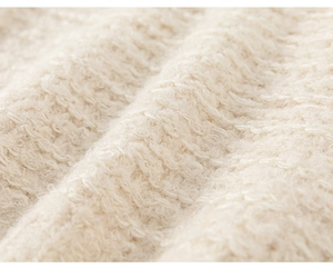 Detailed macro view of high-quality apricot bouclé fabric texture for girls' sweater
