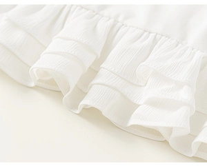 Detail van witte ruffles zoom met verticale geplooide textuur op het kindershirt