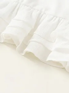 Wit meisjesshirt met lange mouwen, gelaagde ruches en een verticale ribbeltextuur