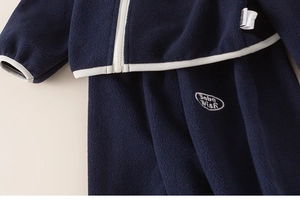 Detail of dark blue fleece tracksuit with white zipper and Baba Wish embroidery