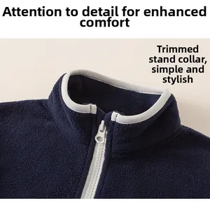 Detail of navy blue fleece jacket showing stand-up collar with piping and silver zipper