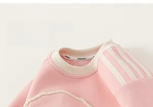 Detail of pink knitted sweatshirt for girls featuring white striped shoulder and soft embroidery