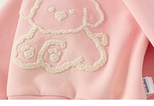 Detail of pink cotton hoodie featuring textured white puppy towel embroidery and soft ribbing