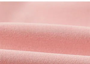 Macro shot of light pink vertical ribbed knit fabric texture showing soft cotton fibers