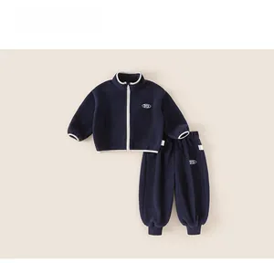 Detailed close-up of navy blue fleece tracksuit for kids with white contrast piping