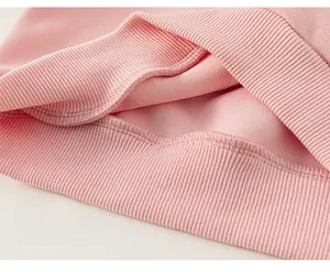 Detail of pink sweatshirt ribbed hem showing elastic fabric and smooth stitching