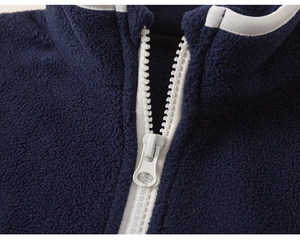 Detail of navy fleece jacket neckline with durable white zipper and soft texture