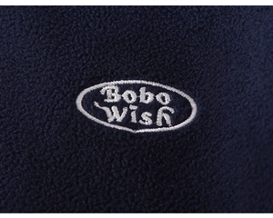 Macro detail of navy blue fleece fabric featuring high-quality white Bobo Wish embroidery