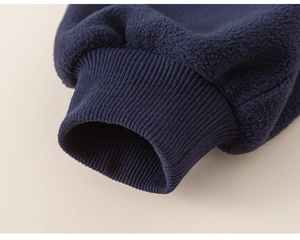 Close-up of navy blue polar fleece fabric and elastic ribbed cuff for kids sportswear