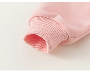 Detail of pink long-sleeve sweatshirt showing soft ribbed knit cuffs and high-quality texture