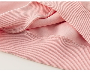 Detail of pink ribbed cuff and professional interior stitching on girls' sweatshirt