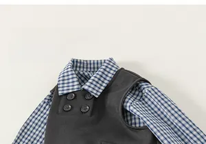 Detail of children's grey knit vest with buttons and blue plaid shirt collar