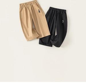 Gros plan détaillé de pantalons pour enfants kaki et noirs avec broderie d'ours mignonne