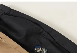 Détail de la broderie d'ours sur le pantalon en sergé pour enfants, texture de qualité