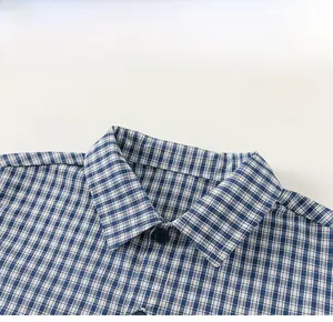 Detail of classic collar and buttons on children's blue checkered long sleeve shirt