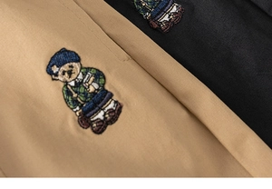 Détail de la broderie ours sur tissu en coton sergé de couleur kaki et noir