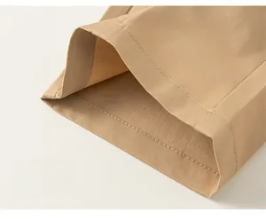Gros plan sur l'ourlet et les coutures du pantalon en coton beige pour garçons