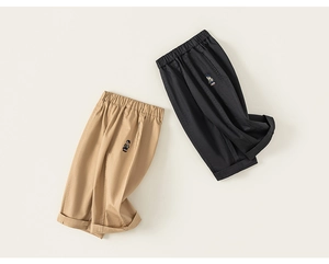 Détail du pantalon pour enfants avec broderie d'ours colorée et taille élastique souple