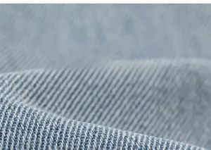 Detailed macro view of light blue denim fabric texture and cotton twill weave pattern
