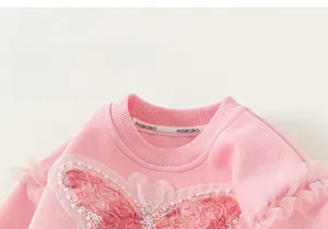 Detail of pink girls' sweatshirt showing sequin butterfly embroidery and floral applique