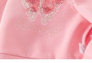 Detailed macro view of 3D fabric butterfly with sequins and pearls on girls' pink sweatshirt
