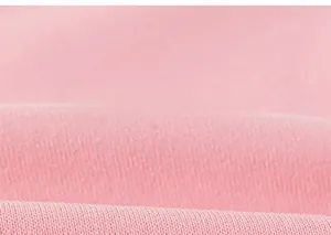 Close-up of soft pink knitted cotton fabric texture with delicate fiber details