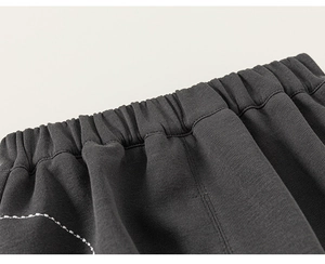 Detail of the elastic waistband and knitted texture of dark grey casual pants