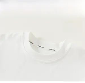 Detail of white cotton long-sleeve tee featuring a ribbed crew neck and fine stitching