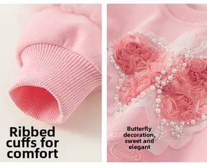 Macro view of pink girl's sweater showing ribbed cuffs and 3D lace butterfly with pearls
