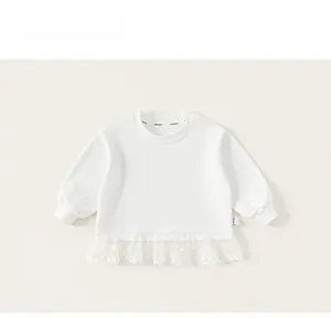 Detail of girls' white long sleeve top with embroidered lace organza ruffle hem