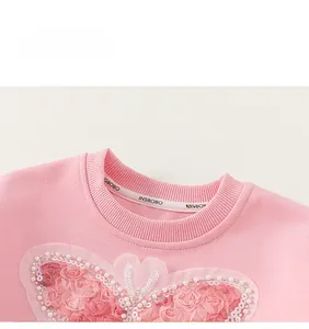 Detail of pink girls sweatshirt featuring handmade 3D roses, white pearls and sequins