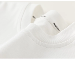 Detail of the white cotton ribbed crew neck and high-quality stitching on the toddler top