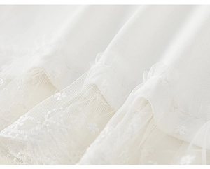 Detail of white cotton shirt with layered mesh lace and delicate floral embroidery