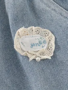 Girls denim pants featuring lace flower patches with pearl bow detail for autumn style