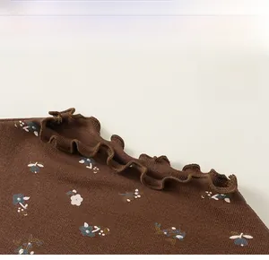 Gros plan sur tricot marron à fleurs avec col à volants et texture côtelée