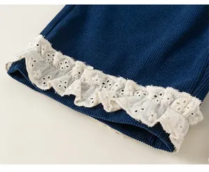 Détail du bas de pantalon en velours côtelé bleu marine avec bordure en dentelle brodée