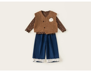 Détail à plat d'un ensemble 3 pièces pour enfant avec haut à fleurs et gilet en tricot