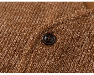 Gros plan sur la texture du tricot caramel avec un bouton rond marron foncé